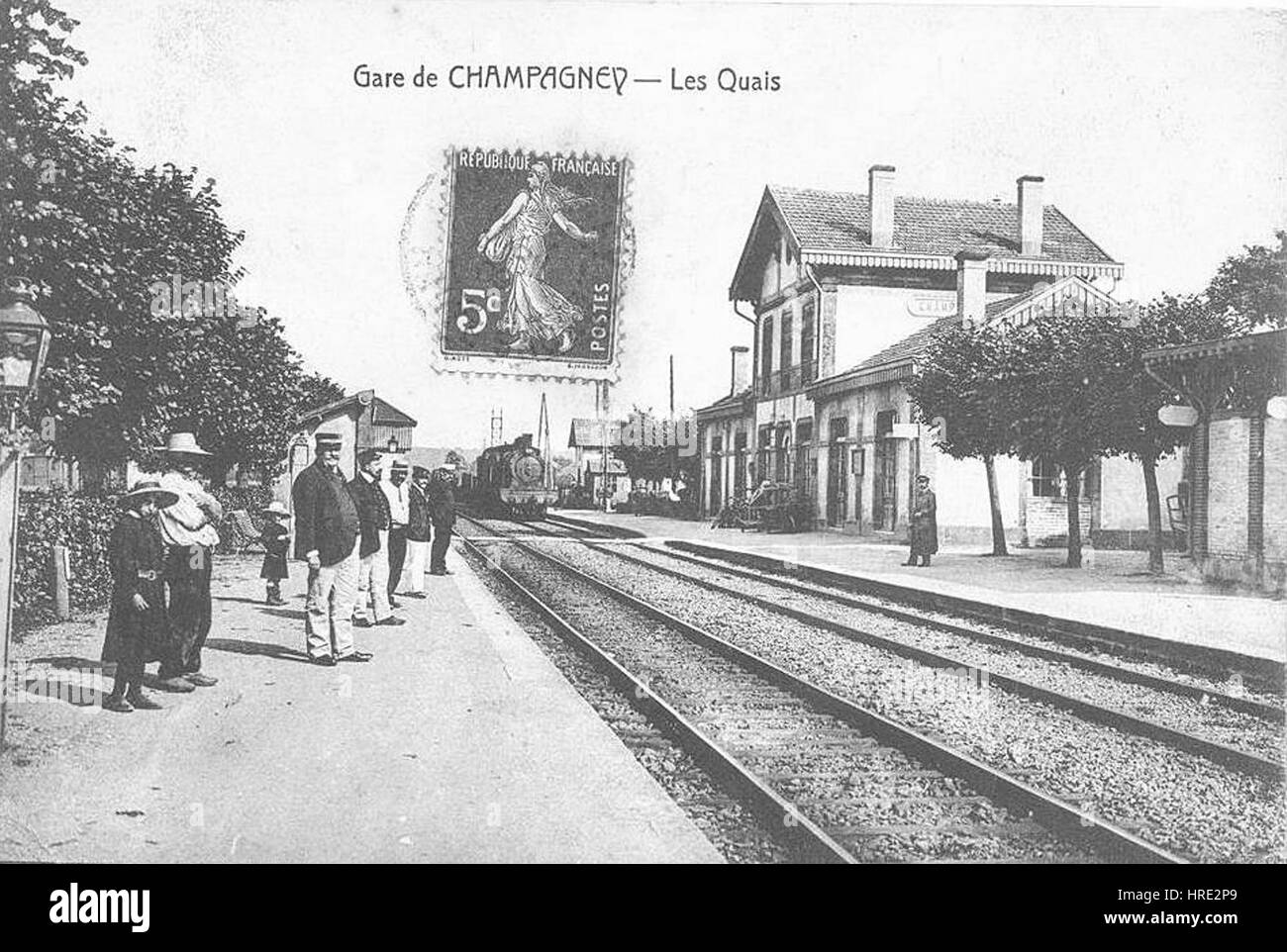 La "Gare-Champagney" raffigura la scena della stazione ferroviaria, mostrando la vivace attività dei viaggiatori e dei trasporti ferroviari. L'opera d'arte riflette l'industrializzazione dell'inizio del XX secolo, enfatizzando l'energia dinamica dell'epoca moderna e l'ascesa dei trasporti come elemento chiave nella vita urbana. Foto Stock