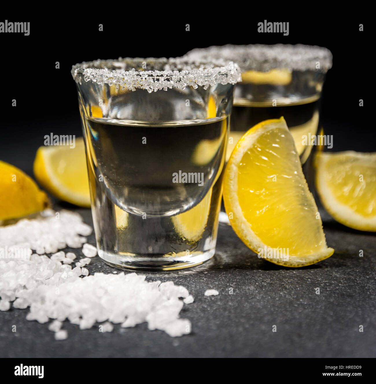 Messicano bevanda alcolica tequila con sale e limone nero sul tavolo di pietra Foto Stock