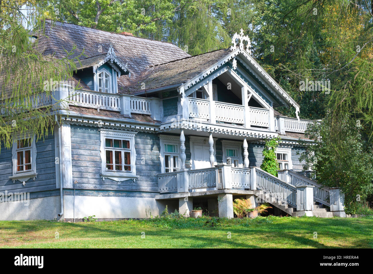 Affascinante vecchio scolpita casa in legno tra gli alberi su un giorno di estate Foto Stock