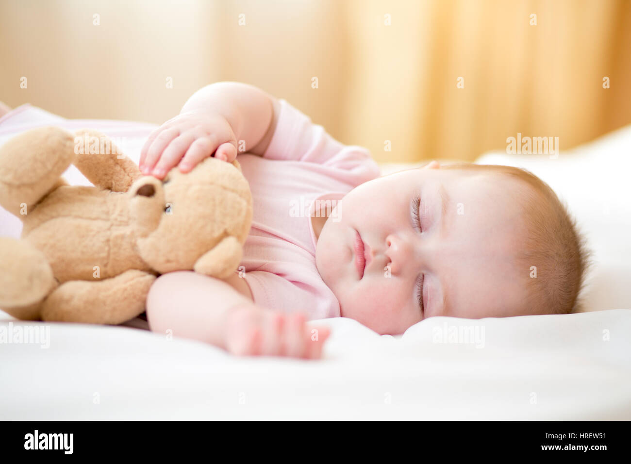 Infant Baby girl dormire con il giocattolo di peluche Foto Stock
