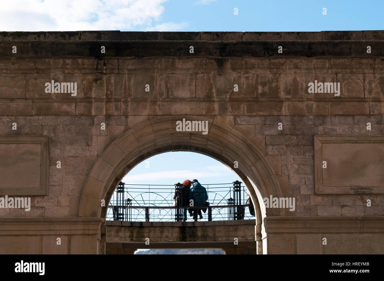 Donostia-San Sebastian: un giovane seduto su una panchina in Parte Vieja, la Città Vecchia e il nucleo originario della città Foto Stock