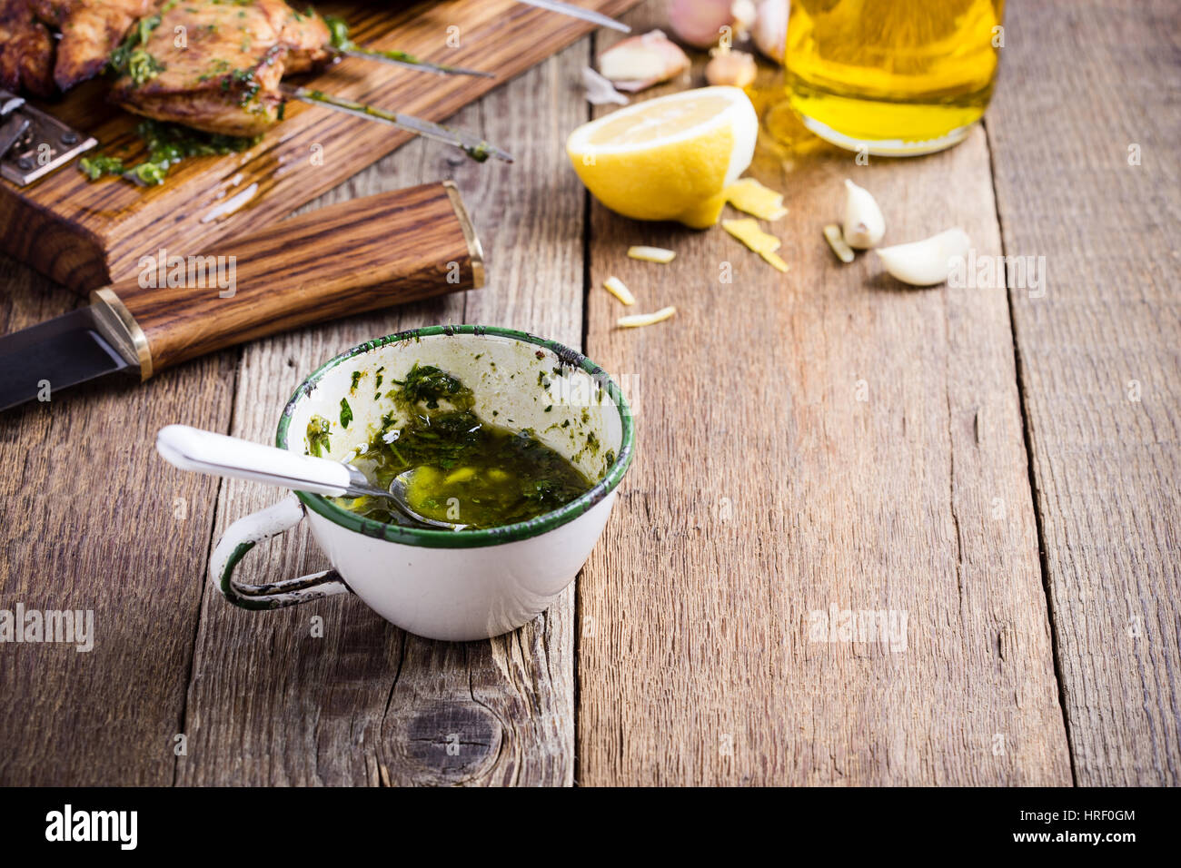 In casa la salsa chimichurri rurali in tazza bianca su tavola in legno rustico, marinata tradizionale o sugo di carne alla griglia Foto Stock