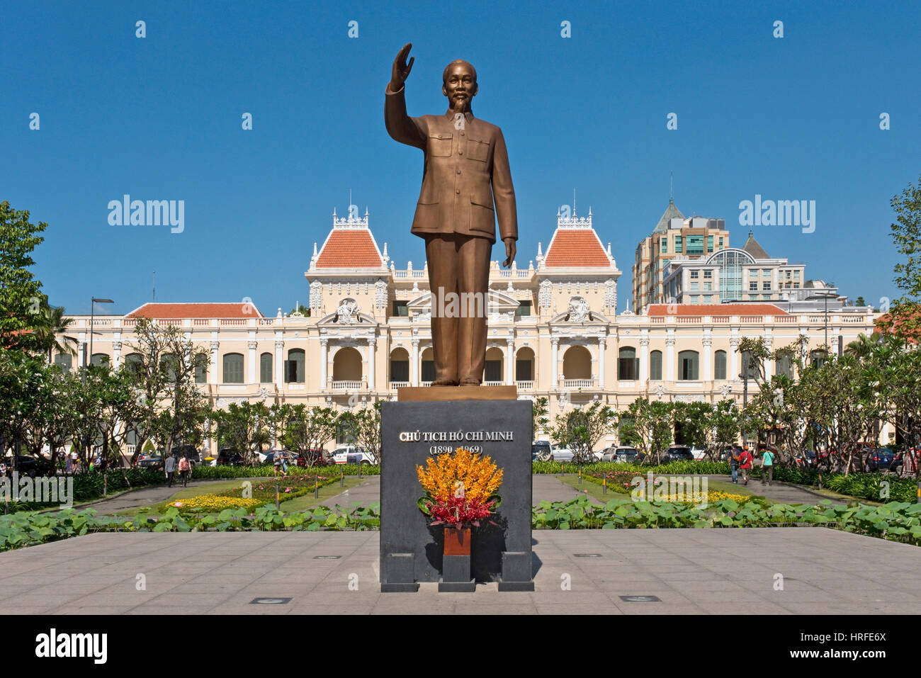 La statua in bronzo di Ho Chi Minh che sorge al di fuori della città di Ho Chi Minh Hall in una giornata di sole con cielo blu. Foto Stock