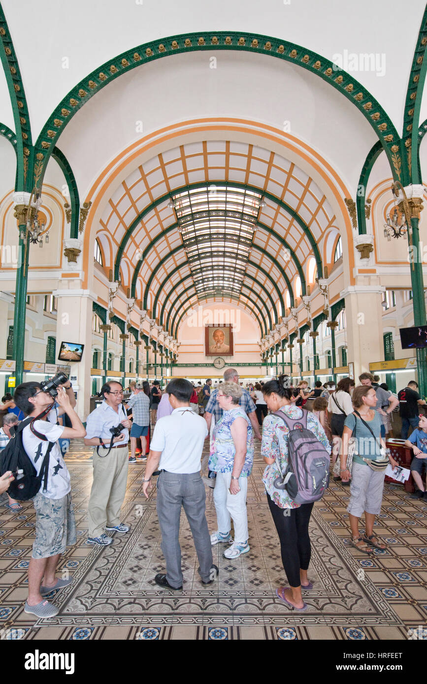 I turisti scattano fotografie e ammirate l'architettura coloniale all'interno del Central Post Office di Ho Chi Minh City. Foto Stock