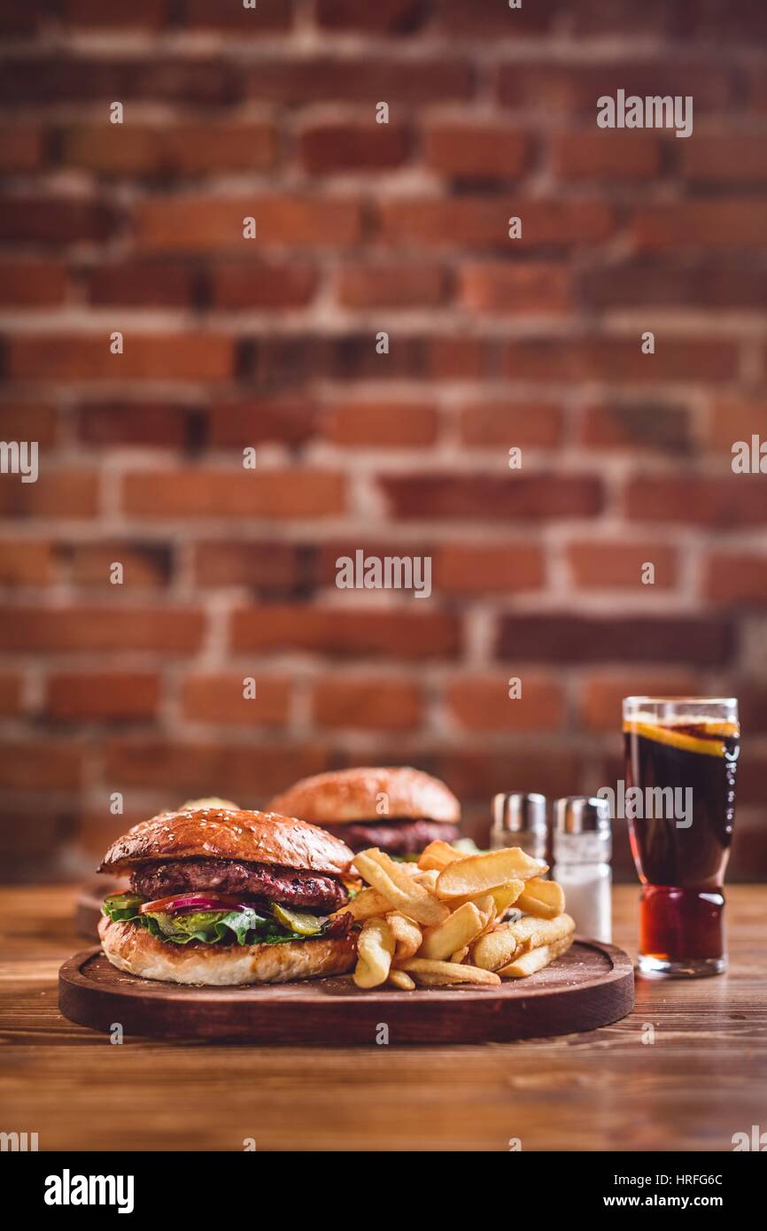 Hamburger freschi sul tavolo di legno Foto Stock