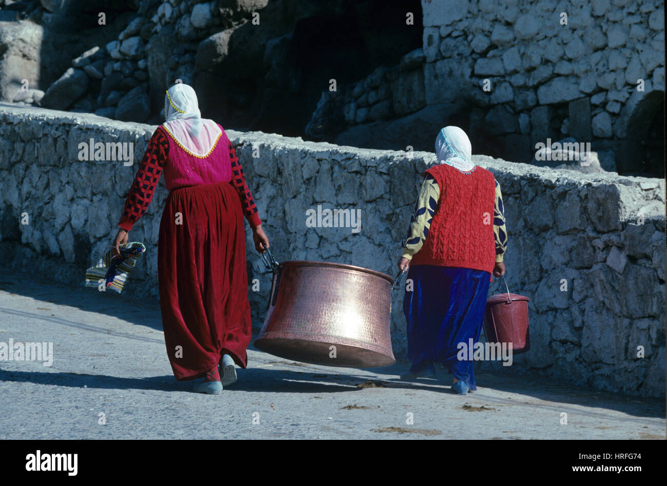 Bagno turco contadino le donne che trasportano gigante paiolo di rame o pentola di cottura Ilhara Cappadocia Turchia Foto Stock