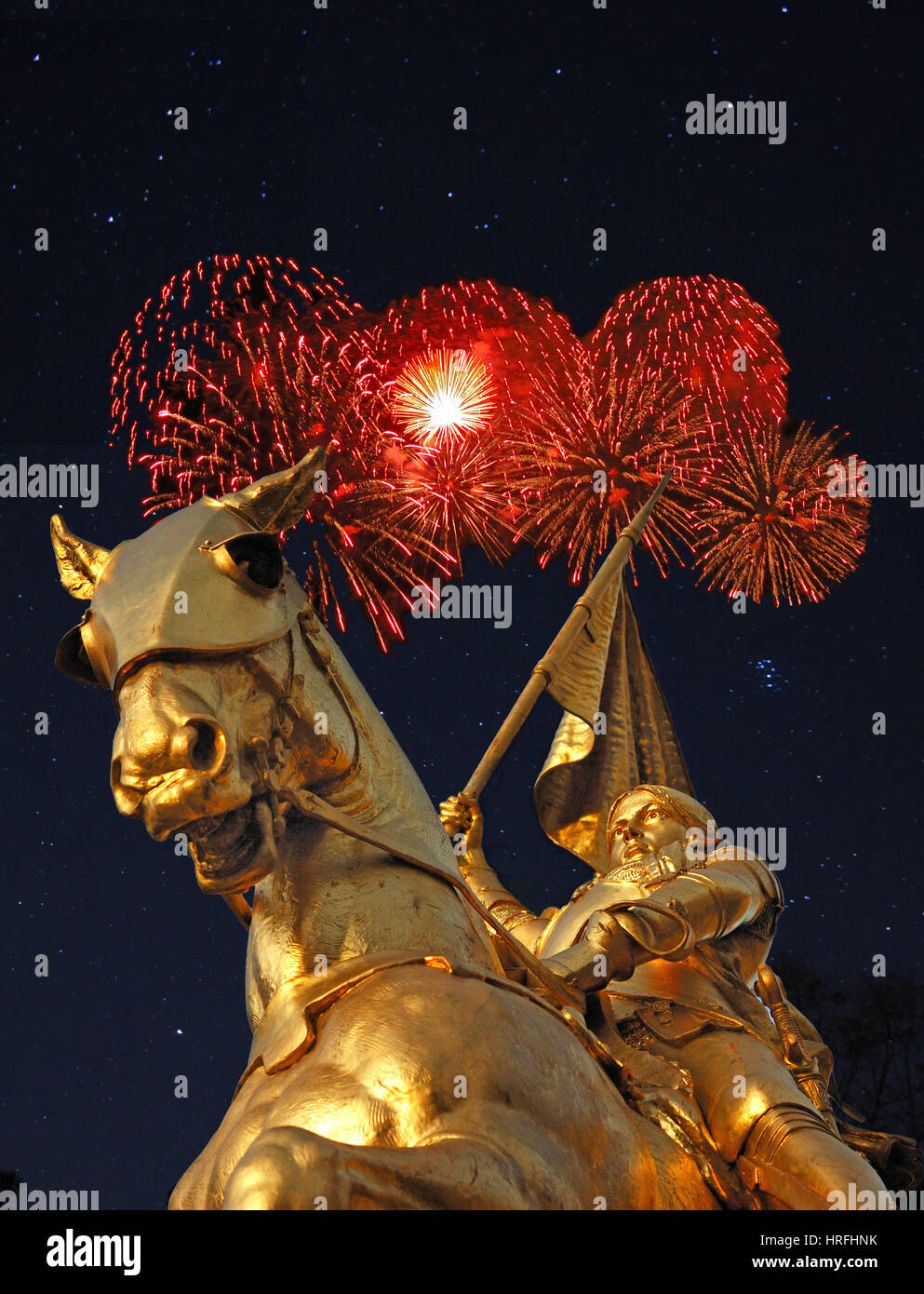 Notte Tempo immagine della statua di bronzo di Giovanna d'arco sulla Rue de Rivoli a Parigi con il rosso fuochi d'artificio in background. Foto Stock