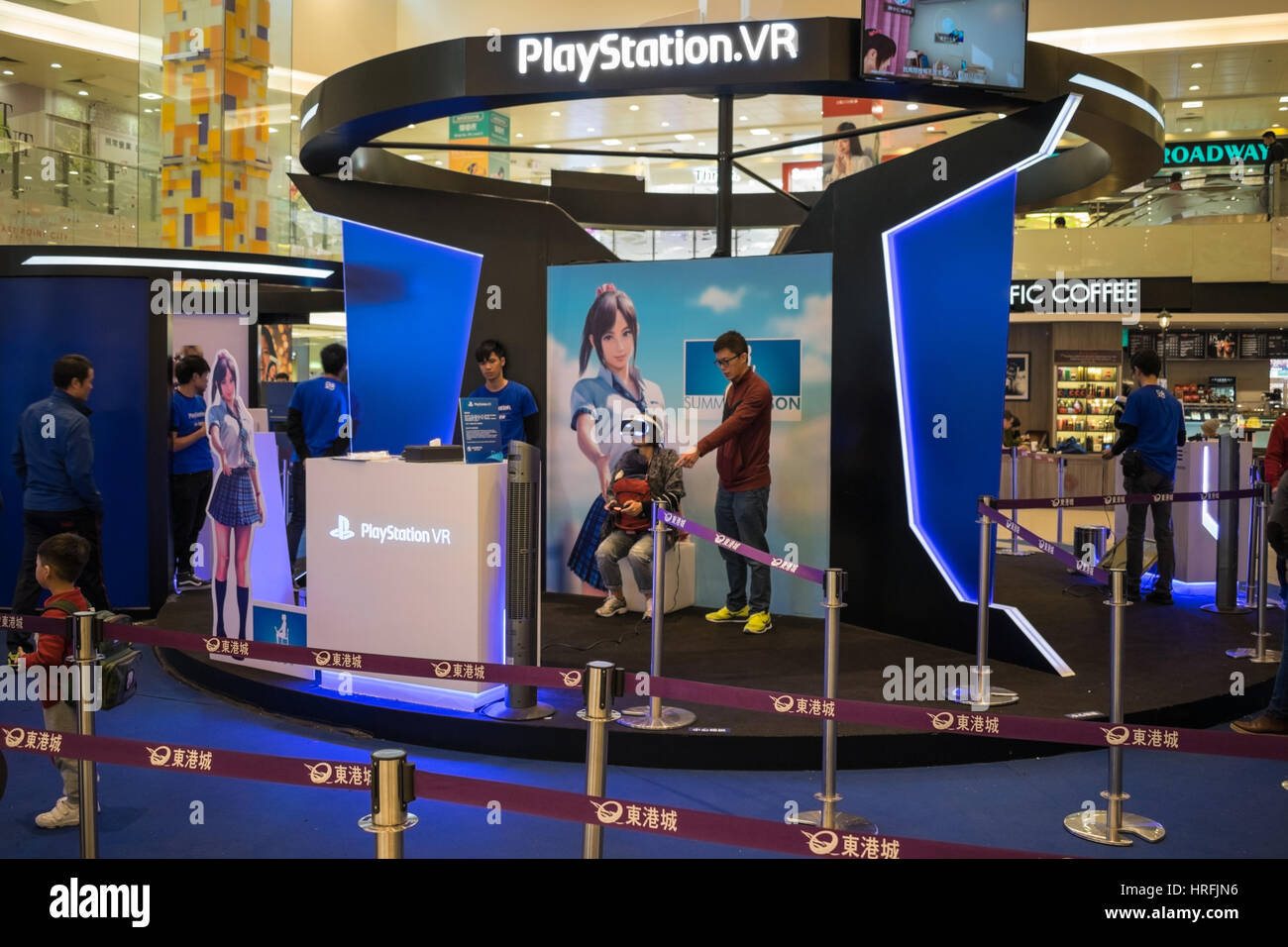 Donna che gioca una playstation in realtà virtuale (VR) gioco tenendo un bambino di hong kong Foto Stock