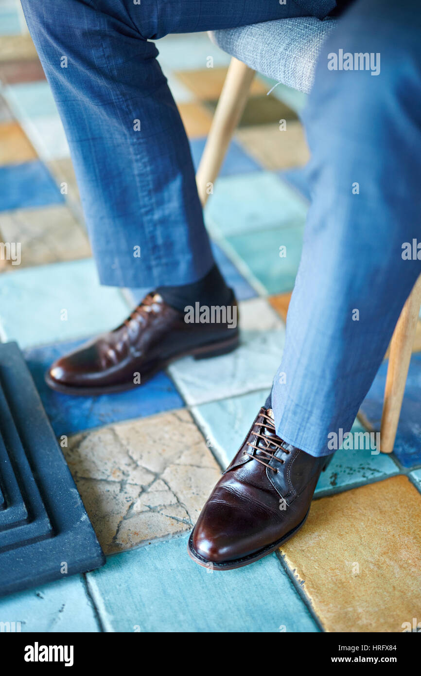Closeup colpo di elegante in pelle marrone calzature uomo su gambe maschio vestita di azzurro vestito formale Foto stock Alamy