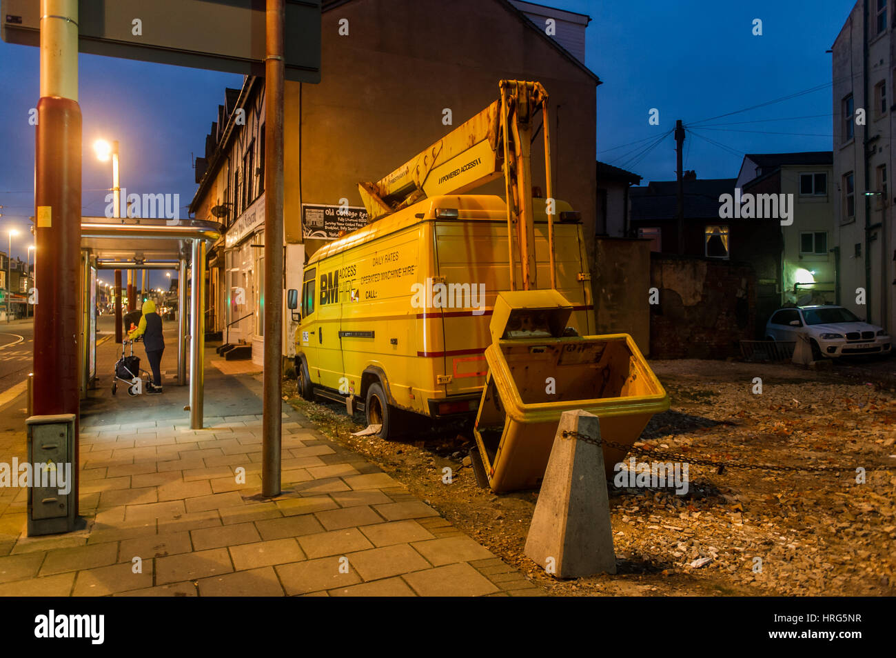 Un dismesse/abbandonate giallo van con un 'cherry picker' ascensore sulla parte posteriore al crepuscolo in Blackpool, Lancashire, Regno Unito. Foto Stock
