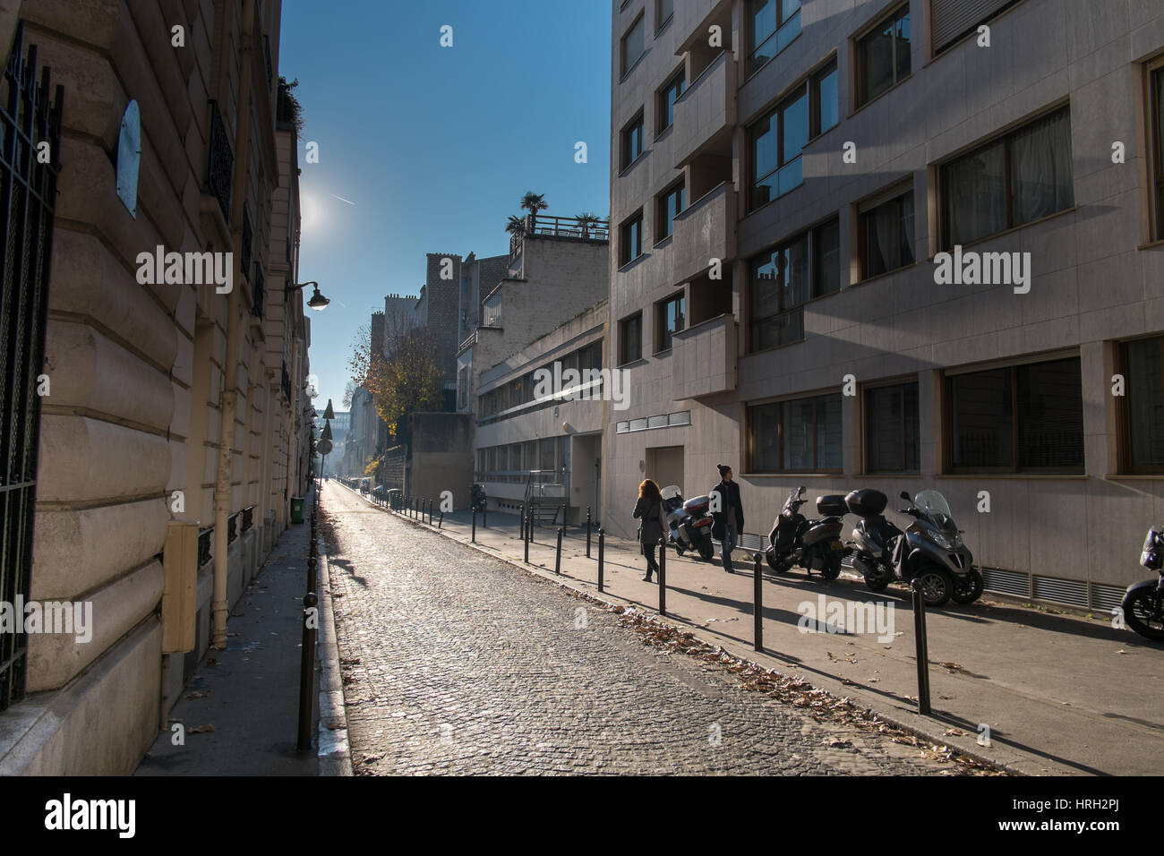 Due figure su una tranquilla strada parigina, il sole invernale e ombre. Foto Stock