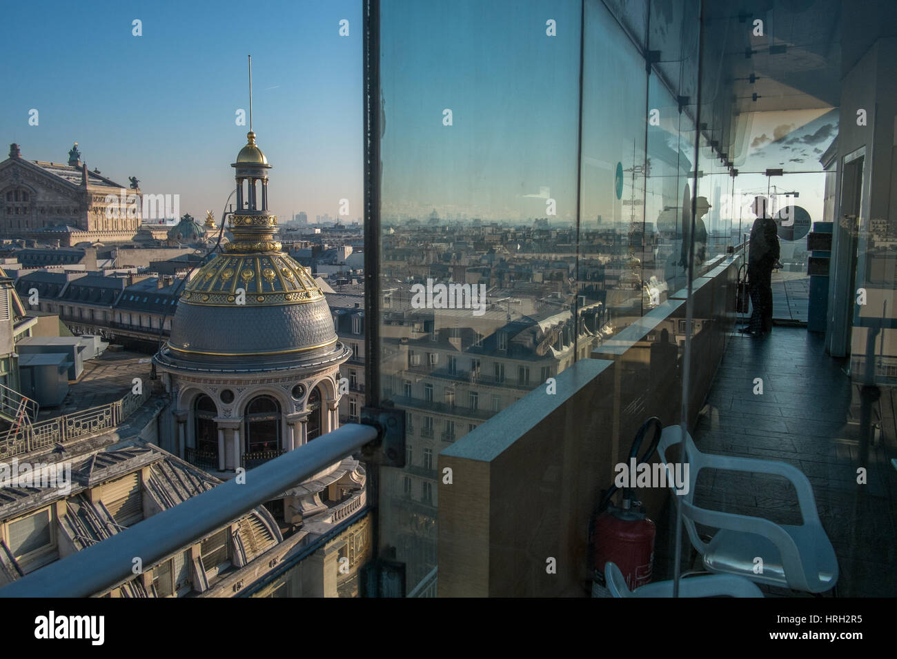 L'uomo la visualizzazione delle cupole ornati dei grandi magazzini Galeries Lafayette risplendono al sole invernale con il Palais Garnier Opera House in distanza. Foto Stock
