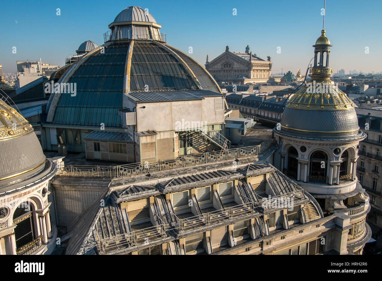Le cupole ornati dei grandi magazzini Galeries Lafayette risplendono al sole invernale con il Palais Garnier Opera House in distanza. Foto Stock
