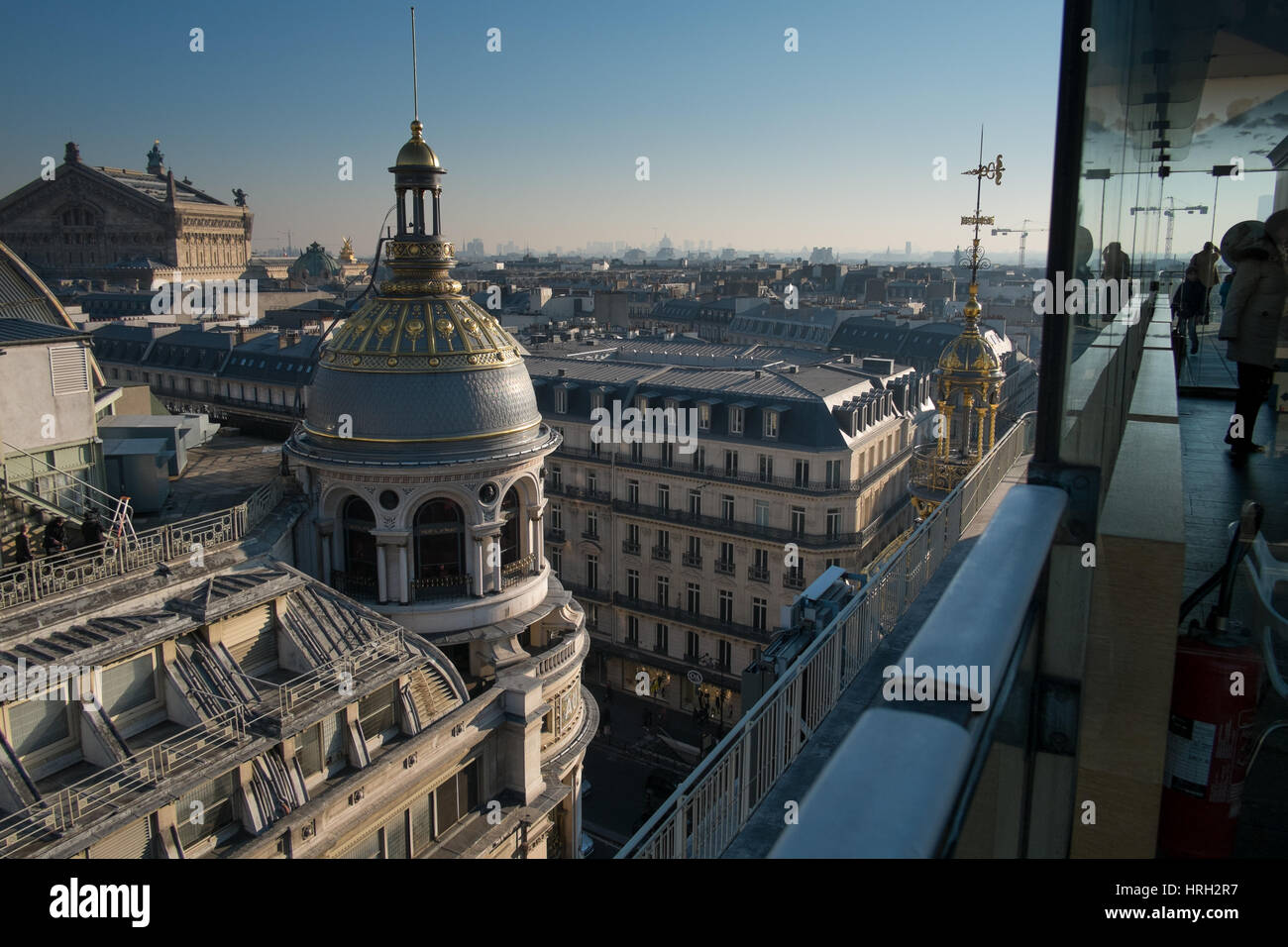 Le cupole ornati dei grandi magazzini Galeries Lafayette risplendono al sole invernale con il Palais Garnier Opera House in distanza. Foto Stock