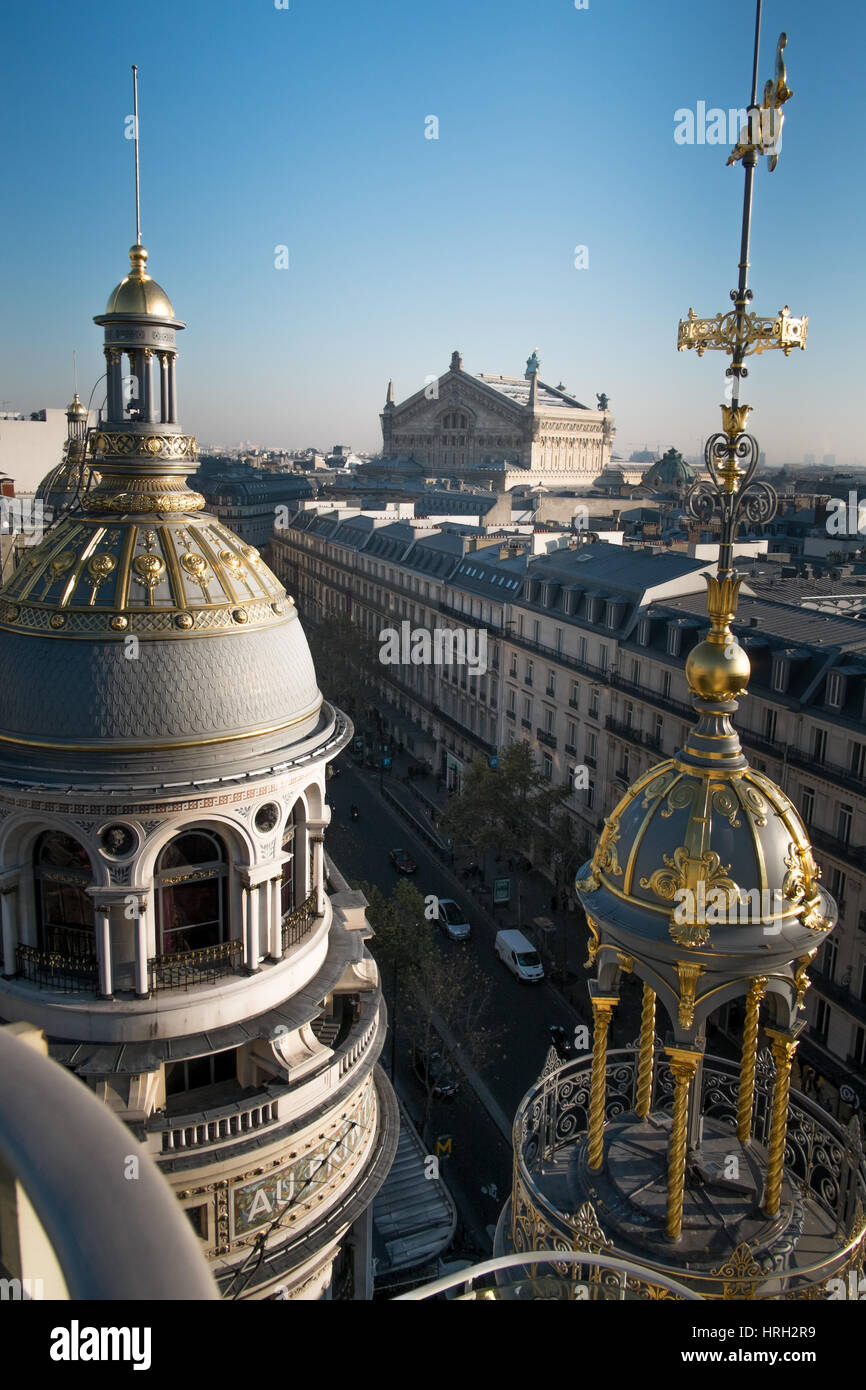 Le cupole ornati dei grandi magazzini Galeries Lafayette risplendono al sole invernale con il Palais Garnier Opera House in distanza. Foto Stock
