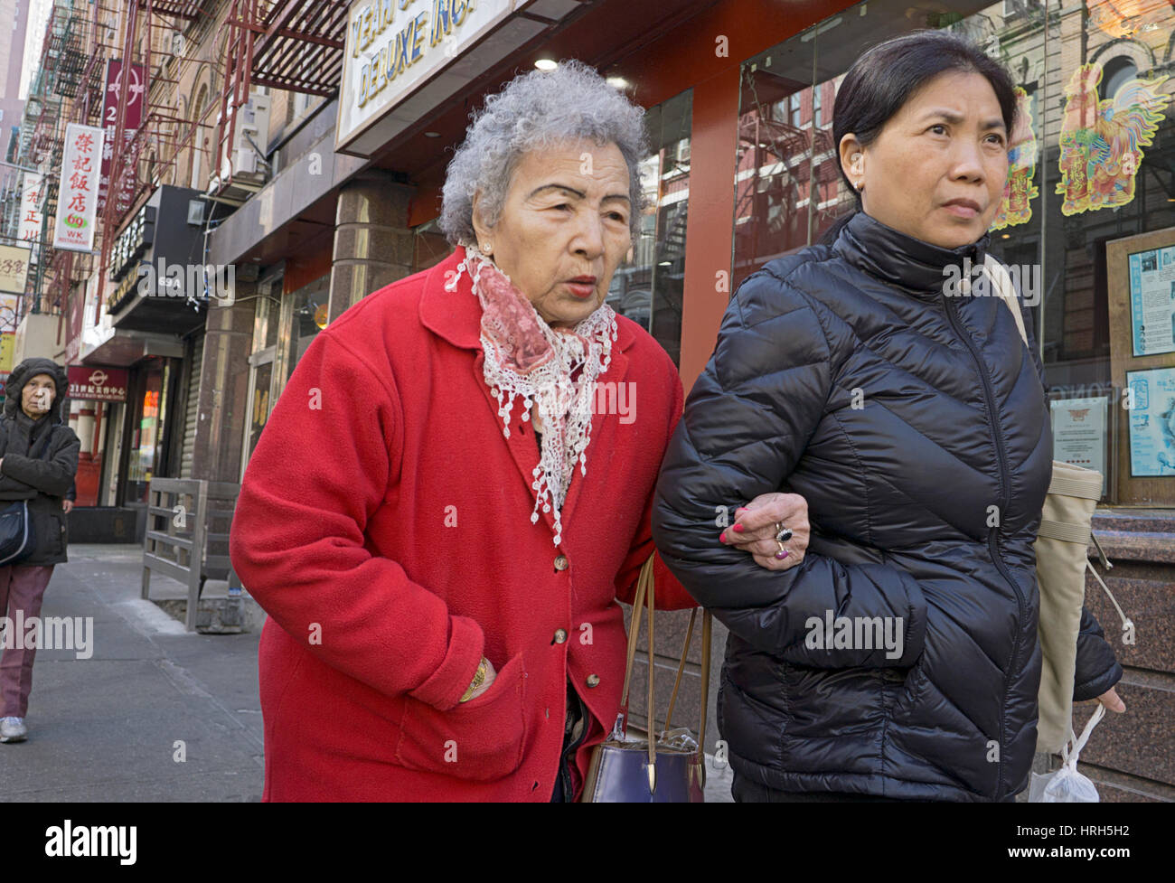 Cinese due donne americane di diversi gruppi di età a piedi su Bayard Street a Chinatown, il centro di Manhattan, New York City. Foto Stock