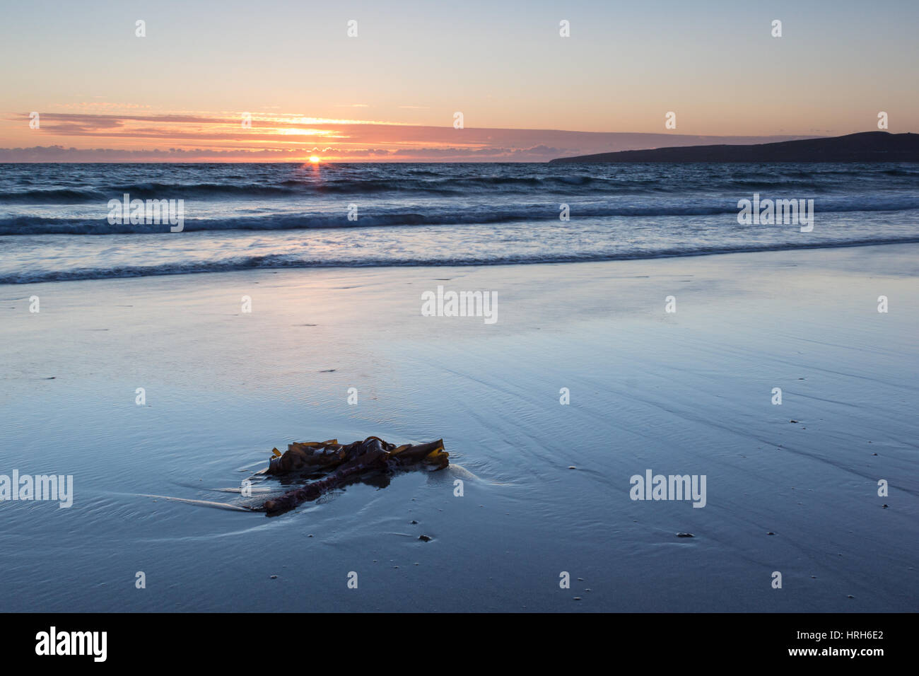 Da soli al tramonto sulla spiaggia Banna, nella contea di Kerry, Irlanda Foto Stock