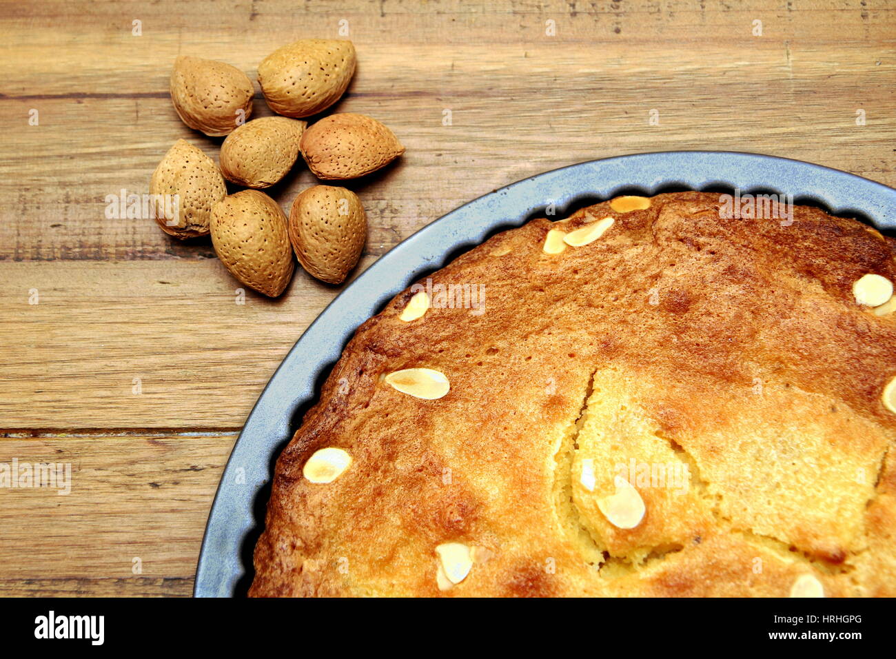 Mandorle senza guscio Noci accanto a un pane appena sfornato frangipane crostata o torta Foto Stock