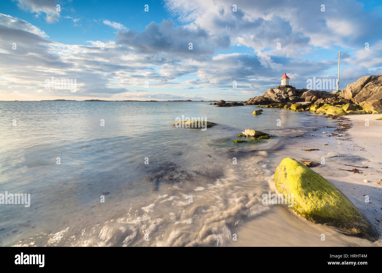 Il sole di mezzanotte si illumina di scogliere e spiaggia di sabbia circondate dal mare turchese, Eggum, Unstad, Vestvagoy, Isole Lofoten in Norvegia Foto Stock