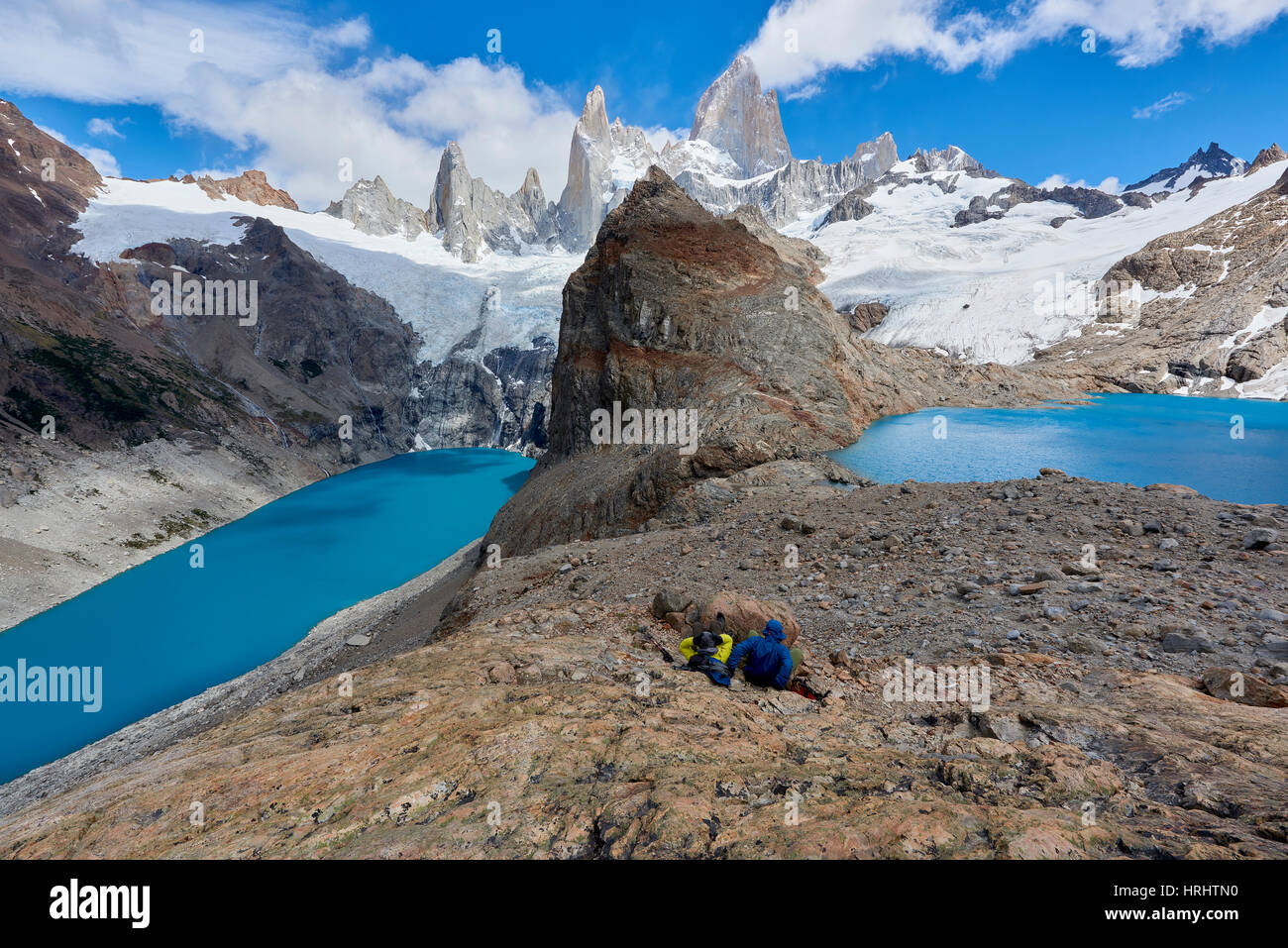 Un giovane in montagna ingranaggio poggia su rocce con vista del Lago de los Tres ed il Monte Fitz Roy, Patagonia, Argentina Foto Stock