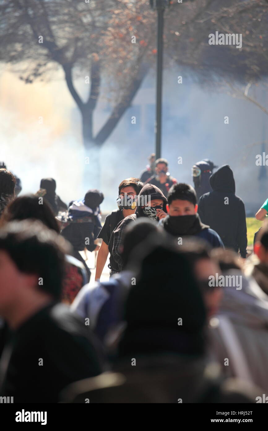 Un gruppo di dimostranti fuga di gas lacrimogeni durante uno sciopero degli studenti in Santiago's Downtown, Cile. Foto Stock