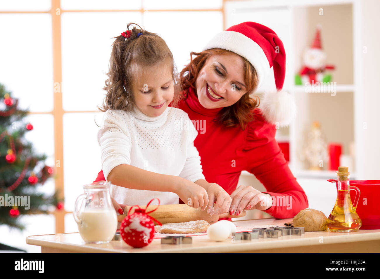 Bambino felice ragazza madre e la cottura X-mas cookie insieme alla festosa sala decorata Foto Stock