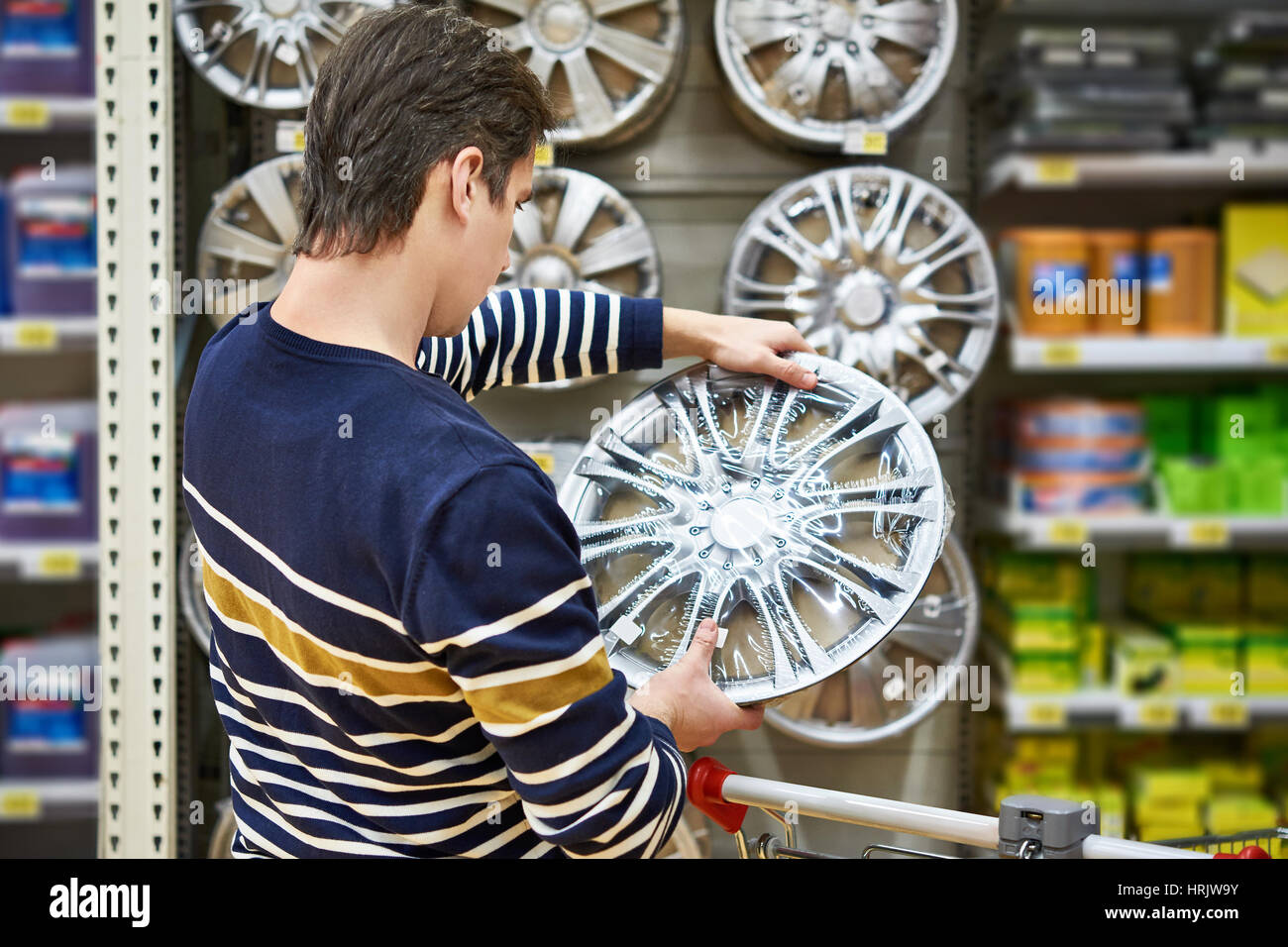 Uomo sceglie i cerchi in lega per la tua auto le ruote nel supermercato Foto Stock