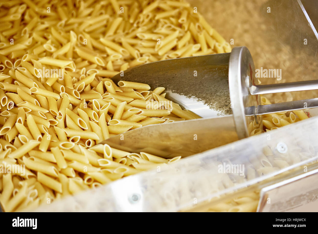La pasta in negozio e un cucchiaio di metallo Foto Stock
