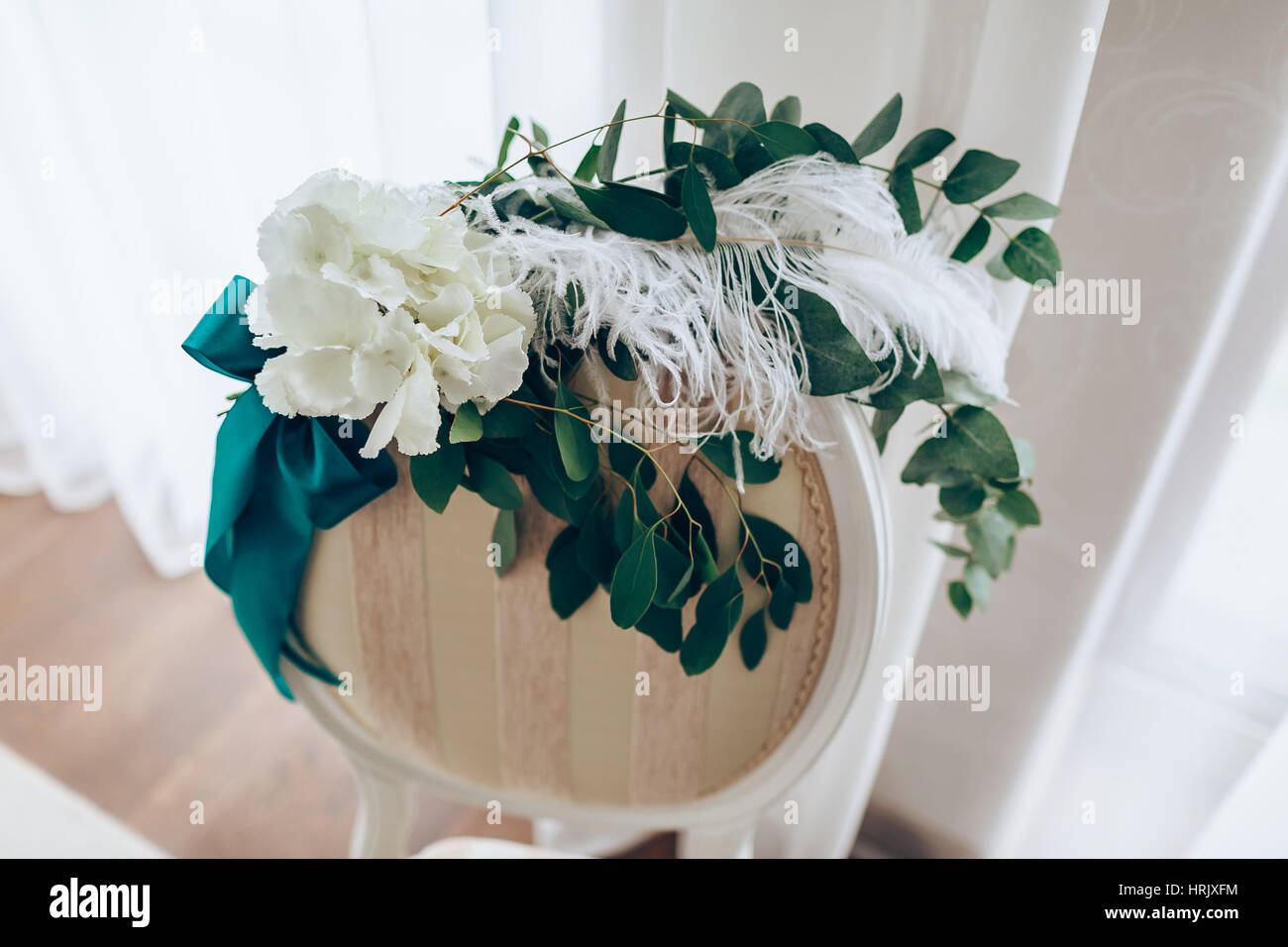 Composizione romantica con rose e piuma sulla sedia all'indietro. Close-up. Foto Stock