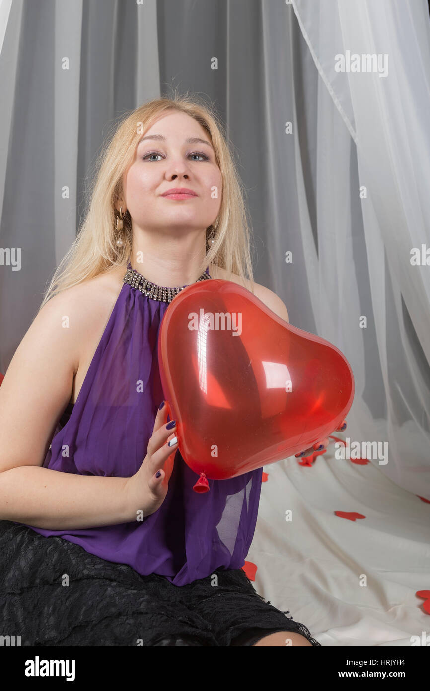 Ragazza giovane con un simbolo dell'amore il giorno di San Valentino in Camera da letto. Foto Stock