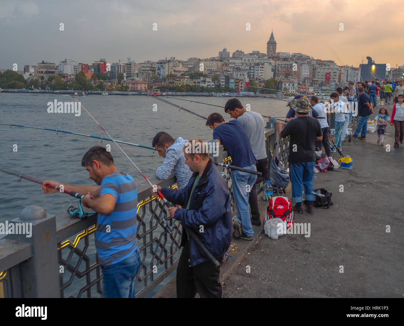I pescatori utilizzando l'asta e la linea pesca dal ponte Galata al crepuscolo Istanbul TURCHIA Foto Stock