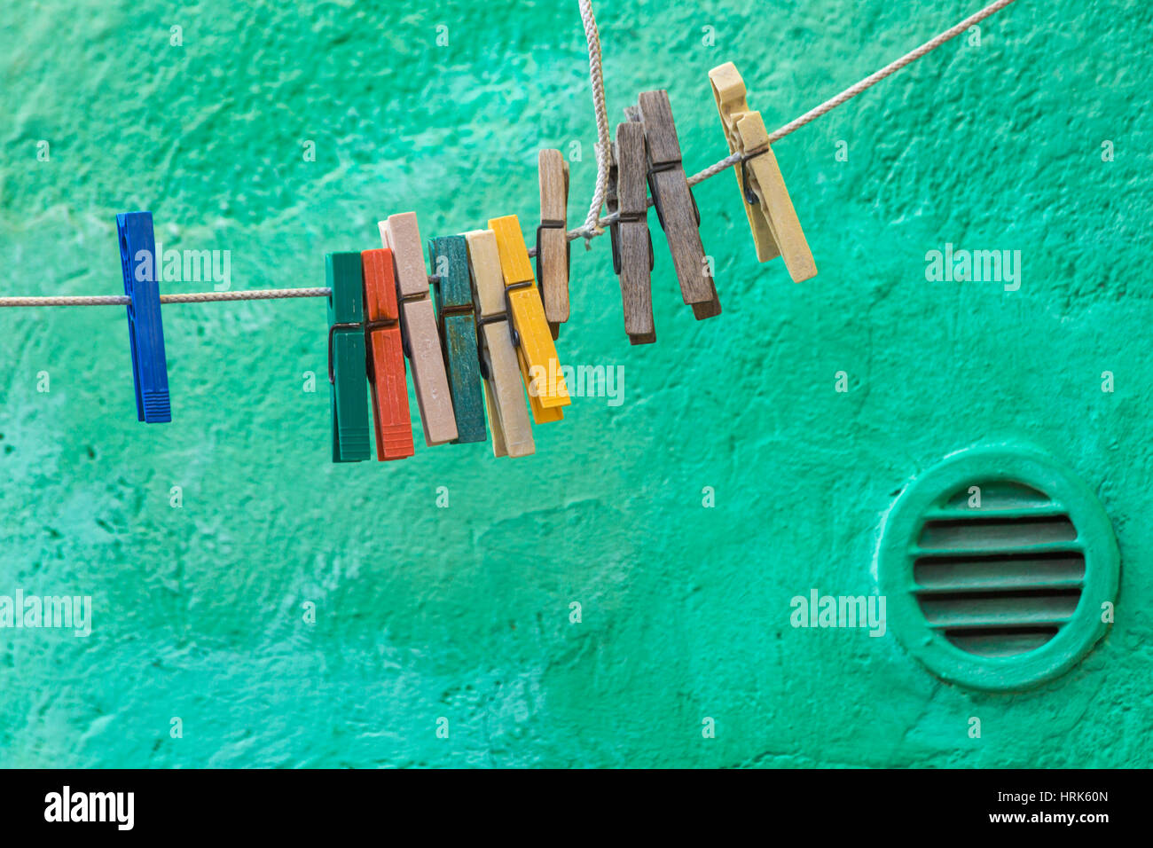 Spine di vestiti appesi sulla linea di lavaggio contro verde parete testurizzata background a Burano Venezia Italia nel mese di gennaio Foto Stock