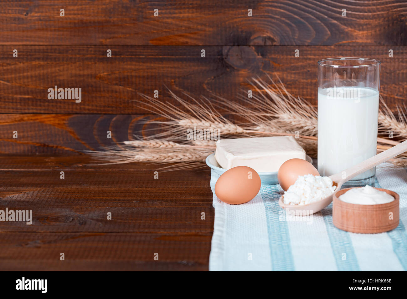 Naturale prodotti fatti in casa: latte, formaggio, panna acida e uova sul vecchio sfondo di legno con spighe di grano. Con spazio per il testo Foto Stock