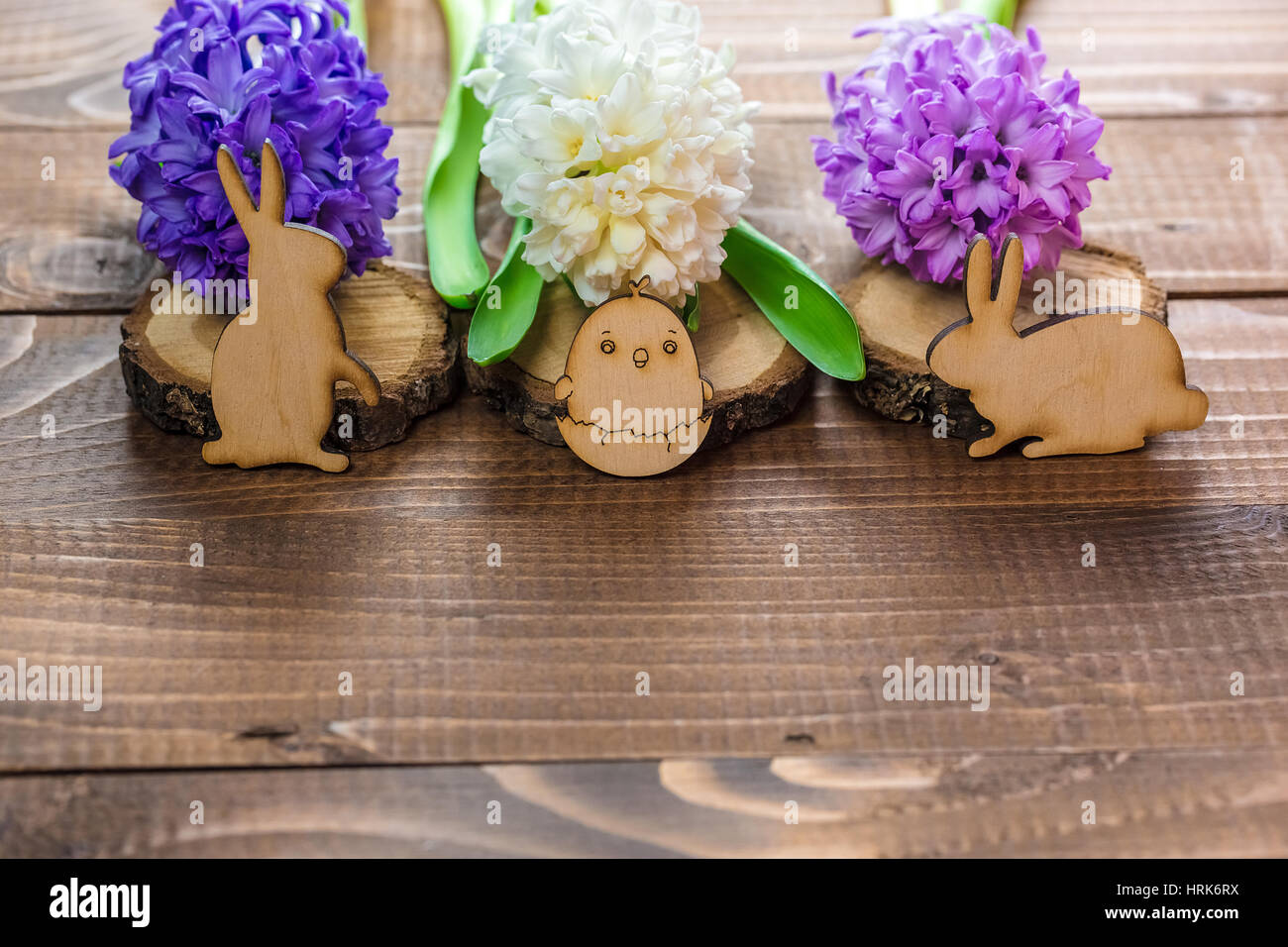 Bella giacinto freschi Fiori e conigli in legno e pollo su schede di marrone. Sfondo della molla per la Pasqua. Spazio libero Foto Stock