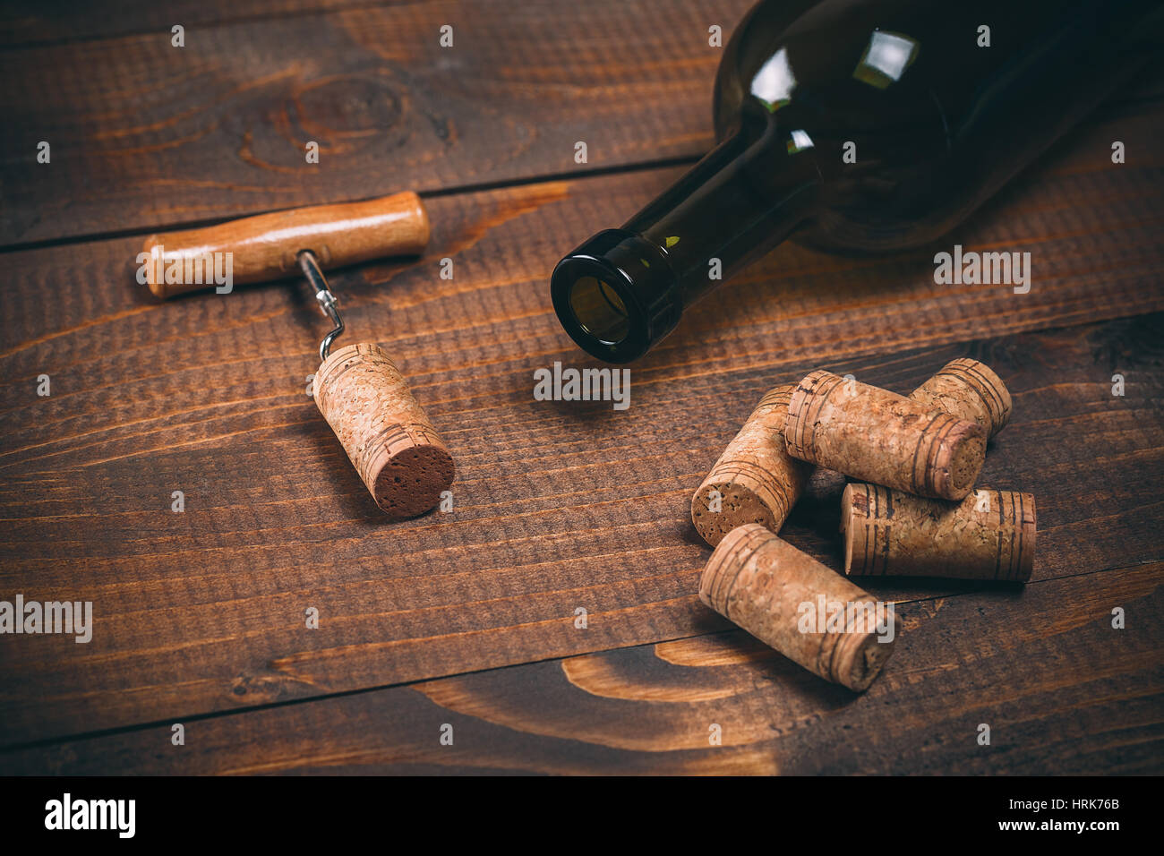 Bottiglia di vino rosso, cavatappi e tappi sul tavolo di legno Foto Stock