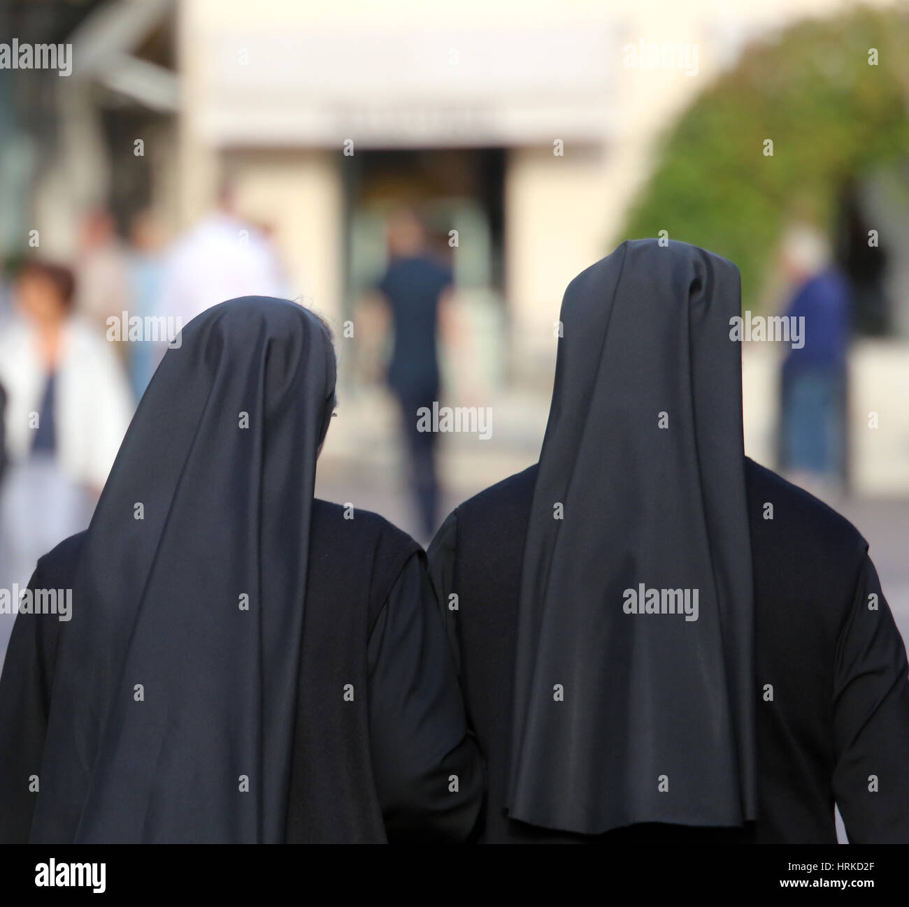 Sorelle con lunghi neri vestiti che a piedi attraverso le strade Foto Stock