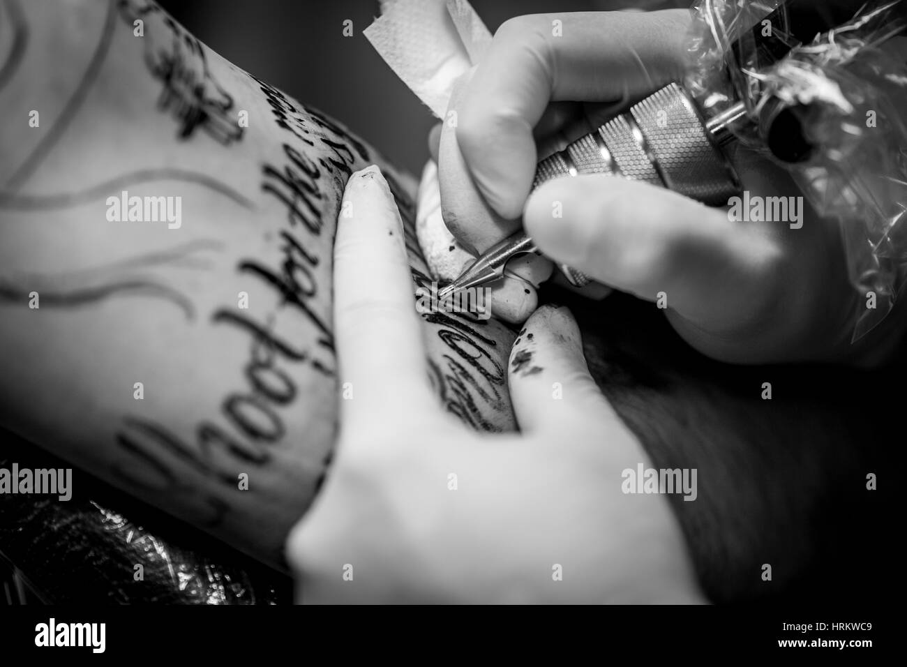 Macro tattooist ago e un tatuaggio sul suo braccio Foto Stock
