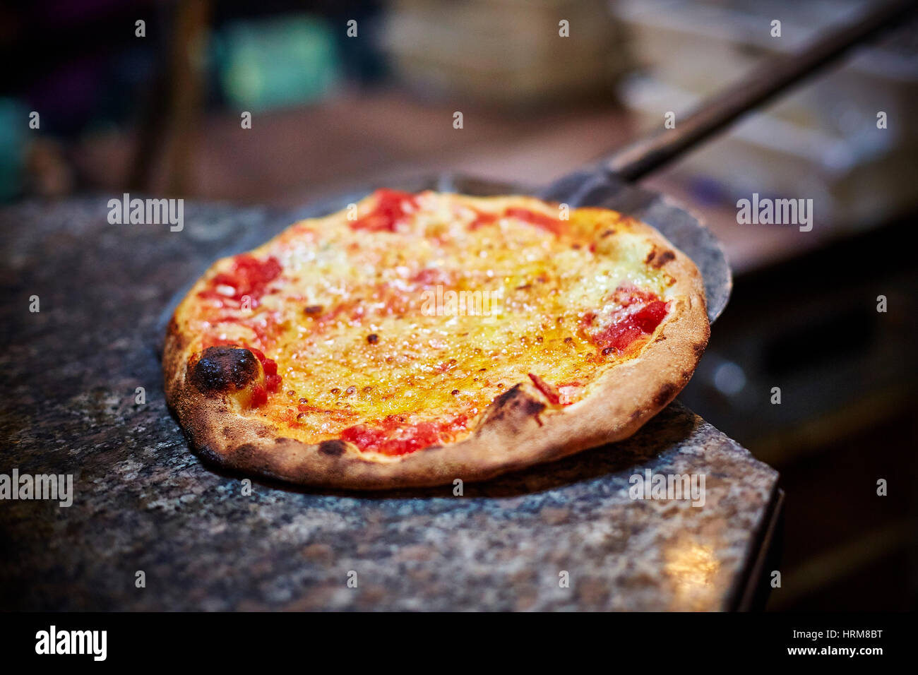 A legna pietra pizza cotta al forno a pale Foto stock - Alamy