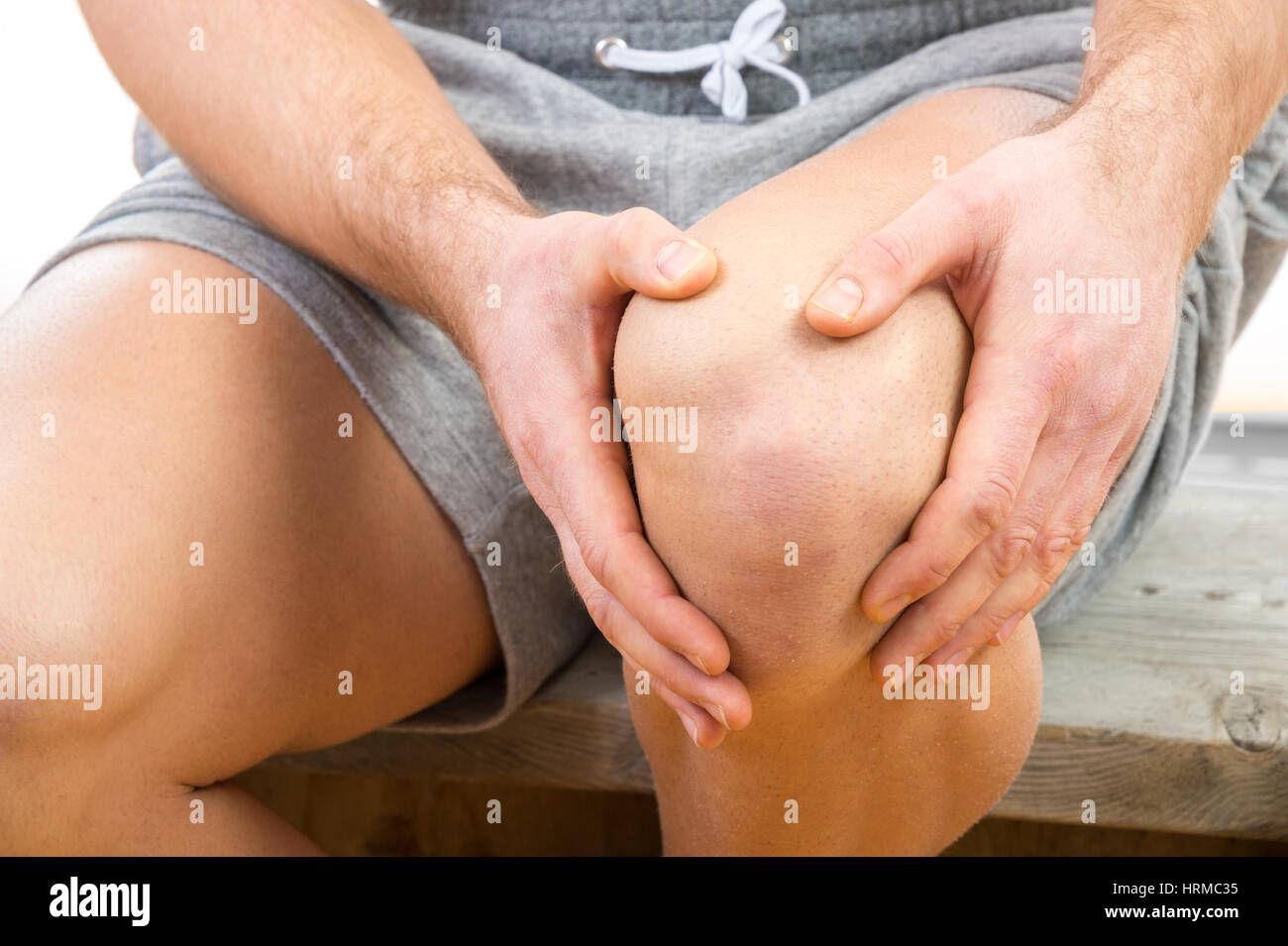 Uomo con il dolore al ginocchio su sfondo bianco Foto Stock