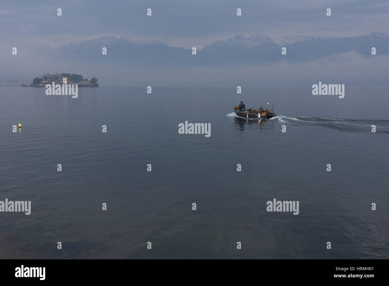 Piccola barca riempito con legna da ardere la mattina presto con la nebbia sul Lago Maggiore, Lago Maggiore, Stresa, Italia Foto Stock