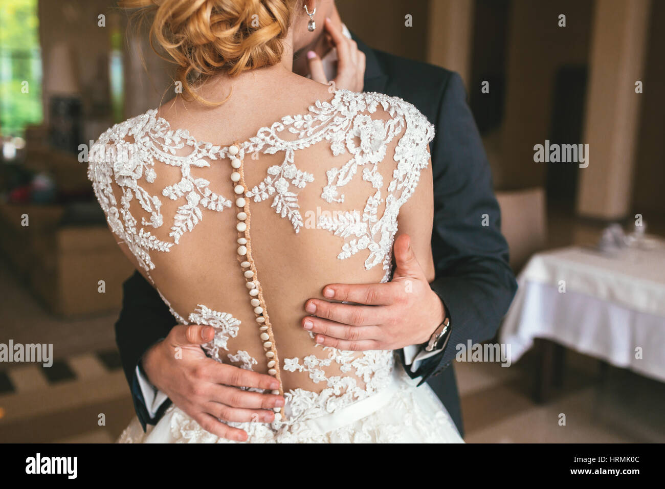 Mano di sposo abbraccia delicatamente la sposa cintola, irriconoscibile close-up Foto Stock