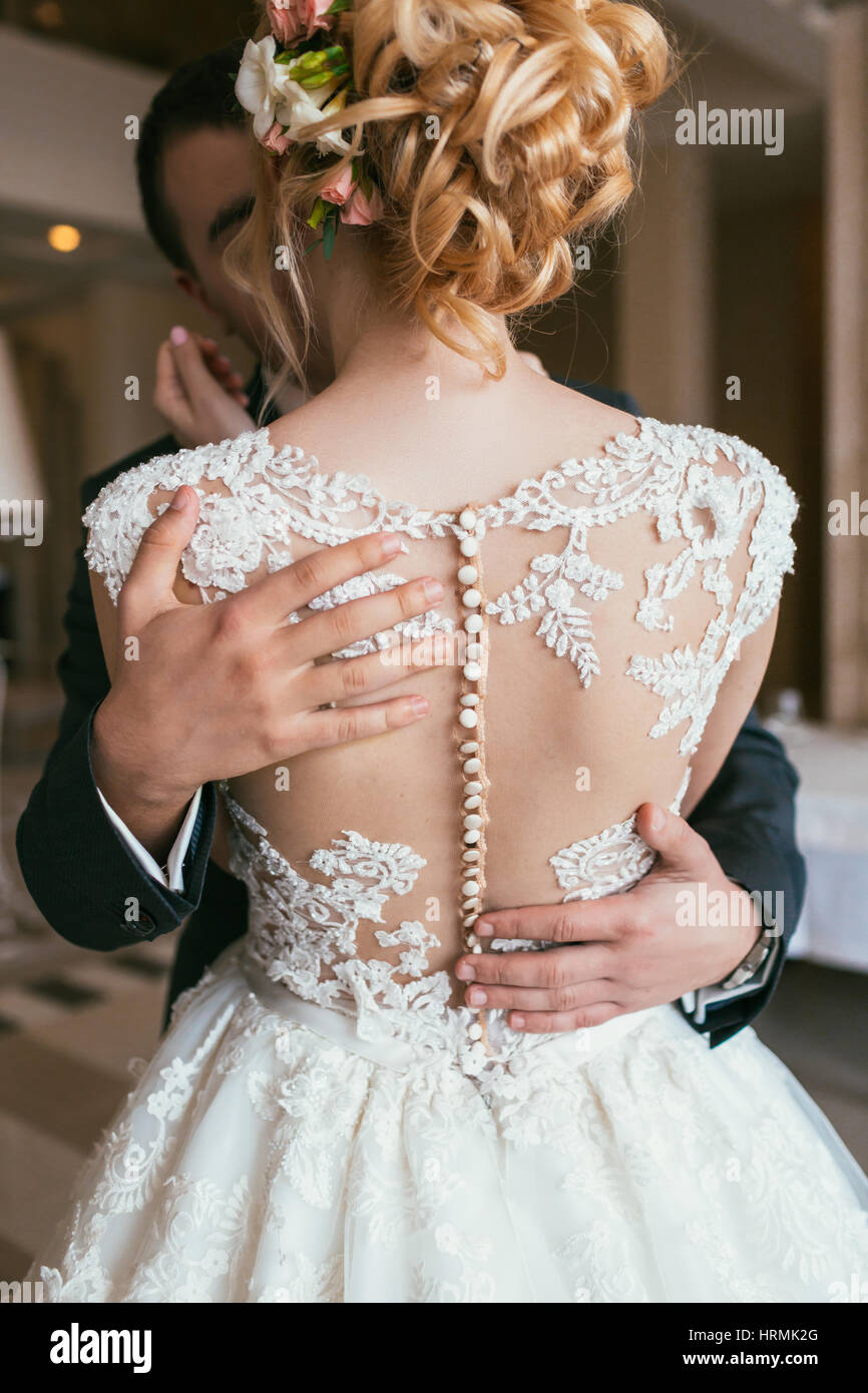 Mano di sposo abbraccia delicatamente la sposa cintola, irriconoscibile close-up Foto Stock
