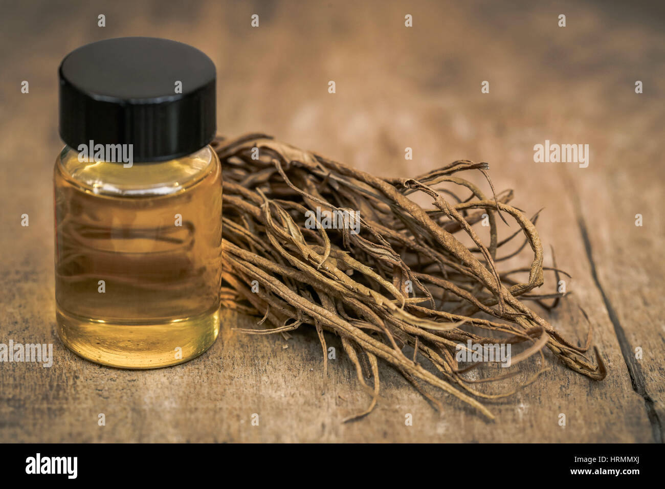 Asciugare le foglie di cannabis medicinale con olio estratto in una bottiglia in superficie in legno Foto Stock