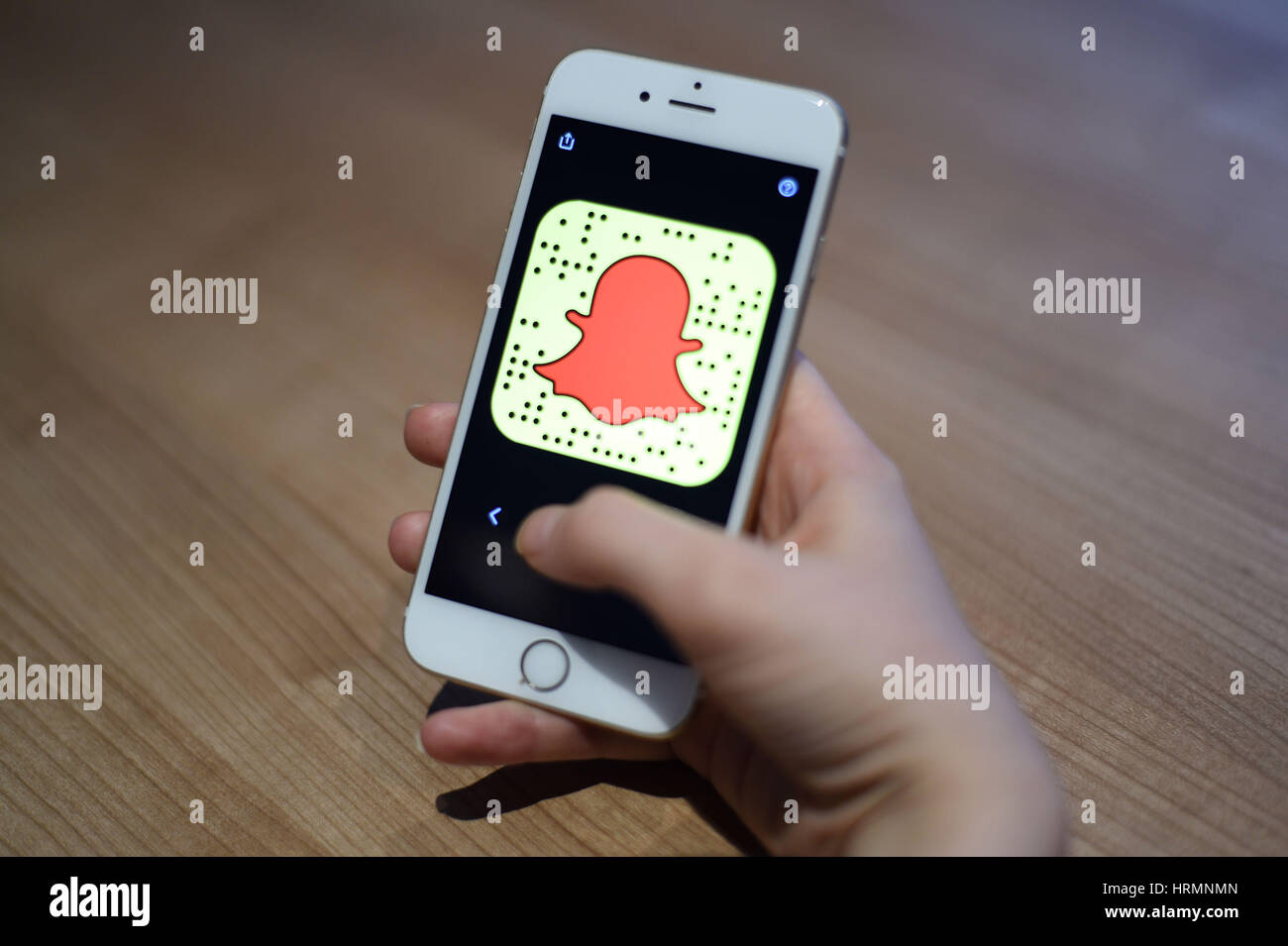 Una vista generale di una donna in possesso di un telefono cellulare con il Snapchat app. Foto Stock