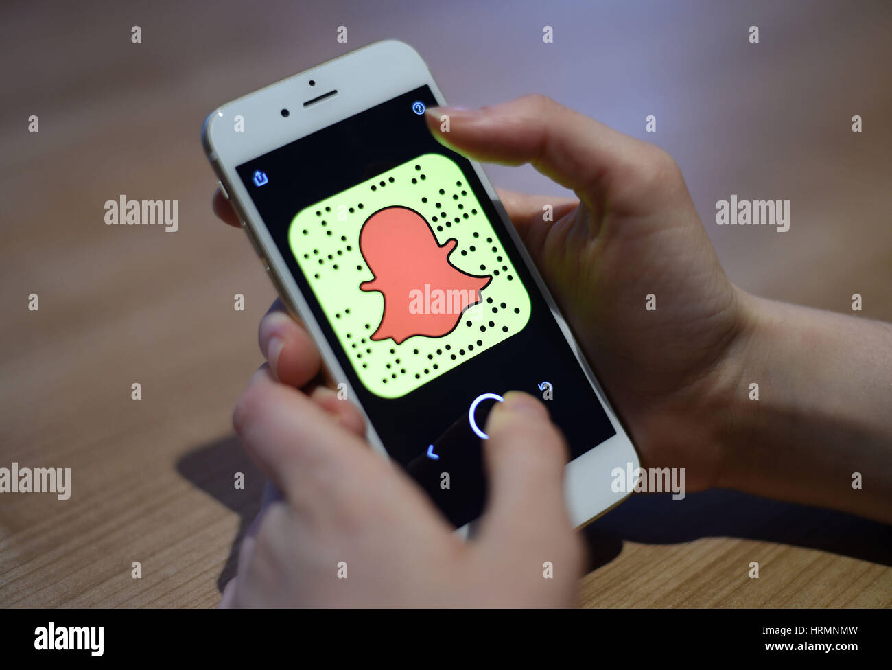 Una vista generale di una donna in possesso di un telefono cellulare con il Snapchat app. Foto Stock