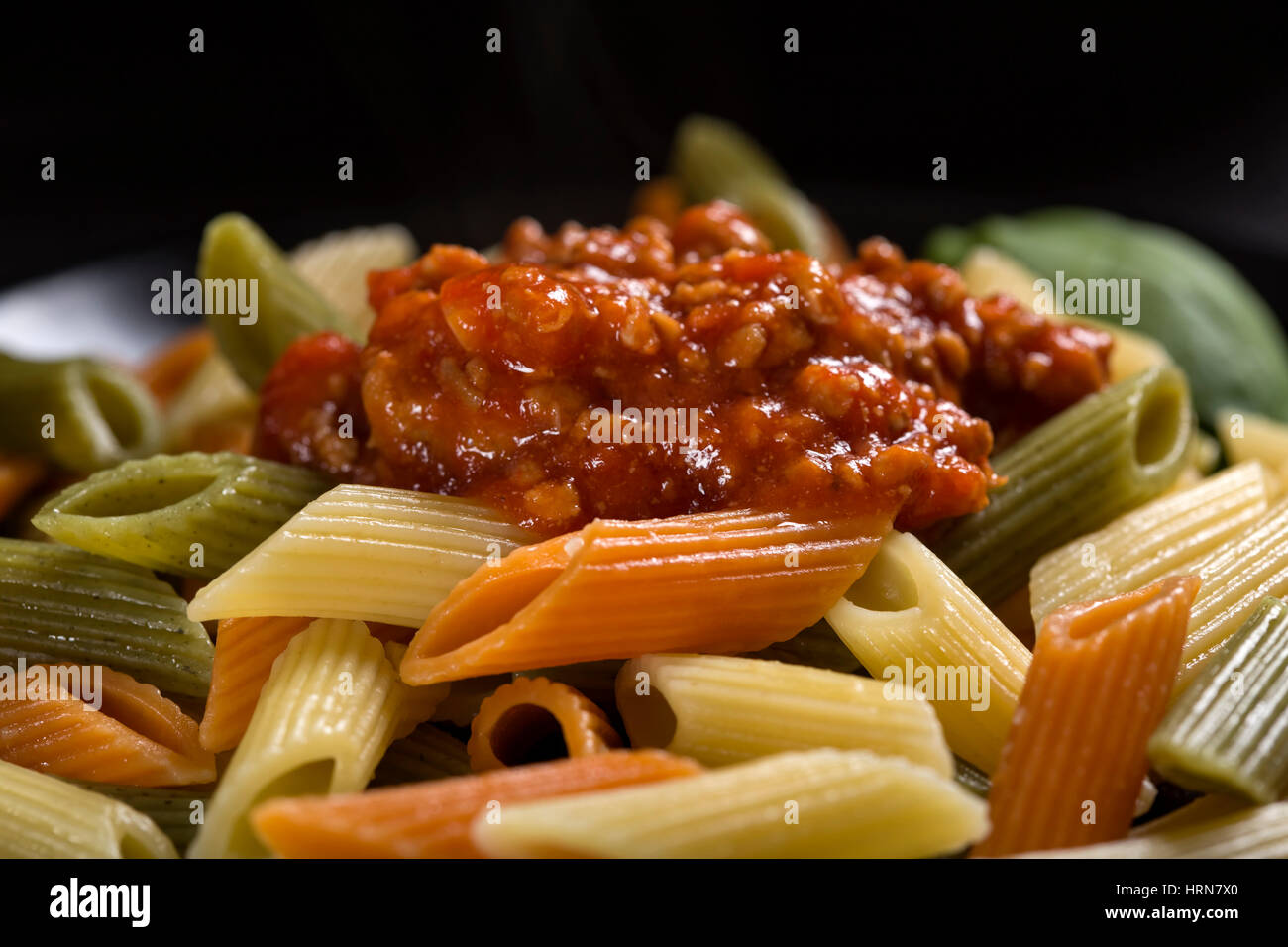 Penne colorate la pasta con il sugo di ragù alla bolognese o la pasta sulla piastra Foto Stock