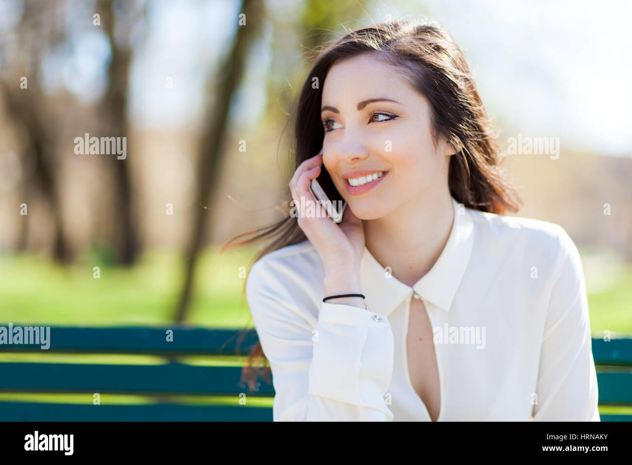Sorridente giovane donna utilizzando un telefono cellulare Foto Stock