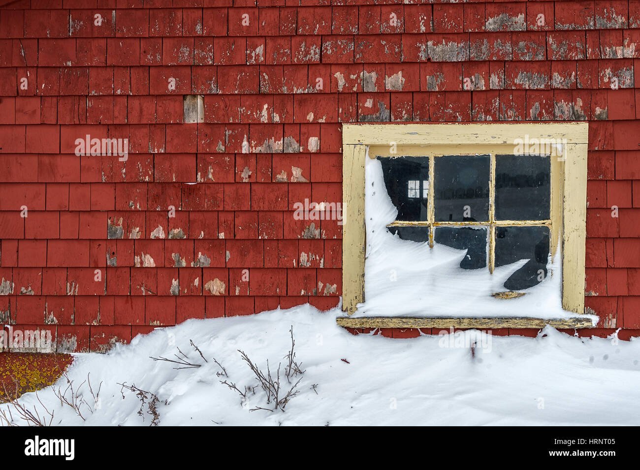 Una finestra di un vecchio fienile spiovente in inverno. Foto Stock