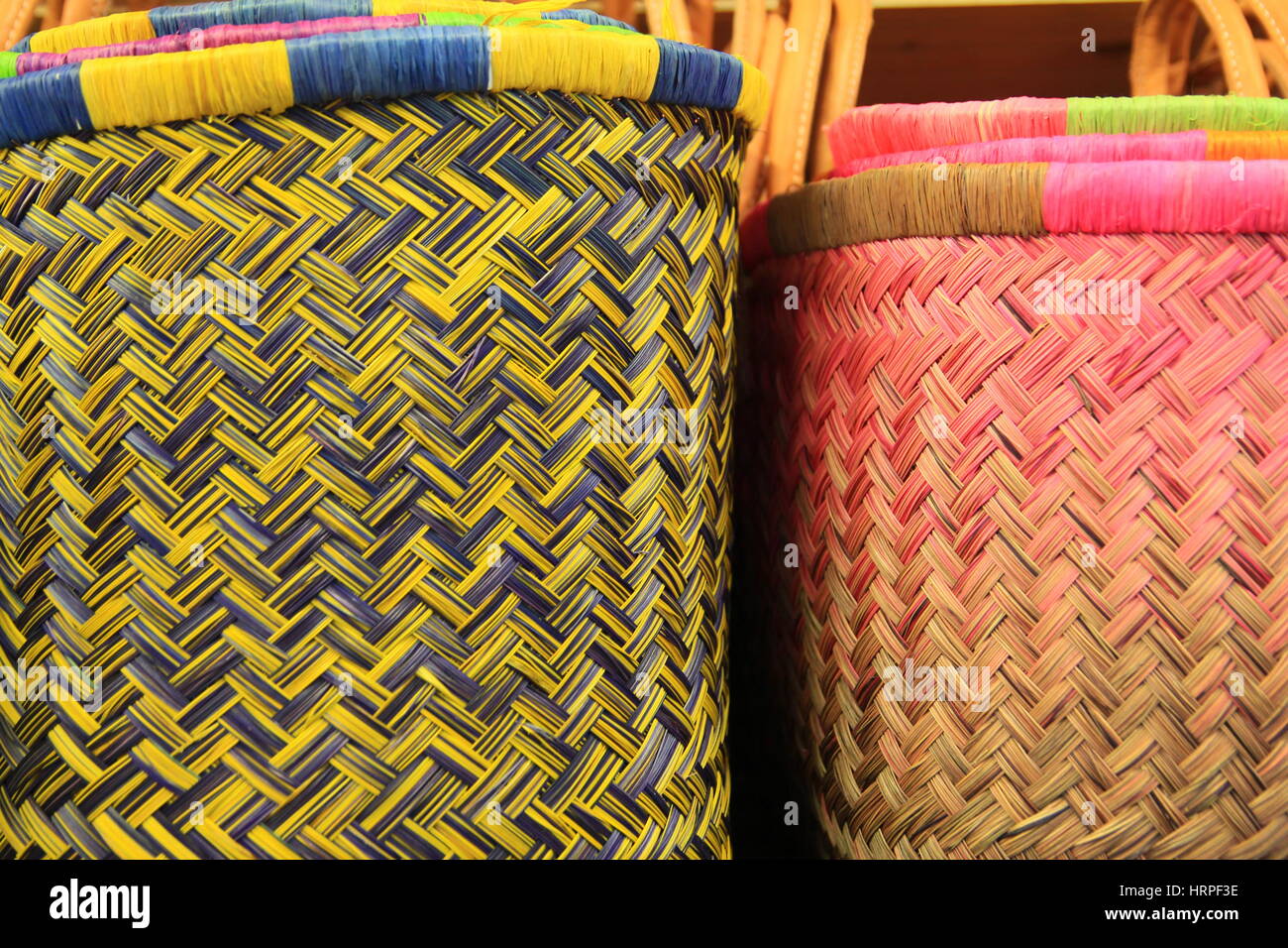 Colorate reed di vimini ceste in blu giallo e rosa con motivo a spina di  pesce Foto stock - Alamy