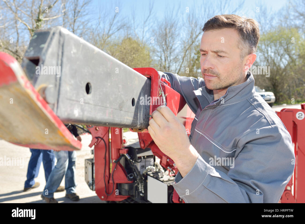 Workman impostazione di macchinari Foto Stock